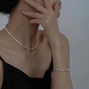 Minimalist silver irregular bead necklace and bracelet set worn on a female model