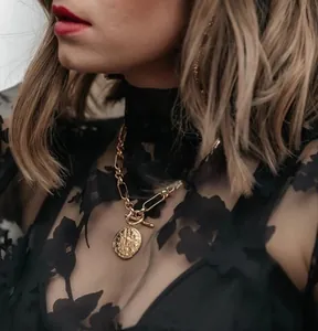 Detalle del collar de cadena de clips gruesa con moneda de oro y cierre OT de perla barroca