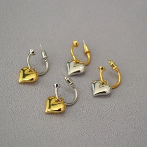 Two-tone heart hoop earrings in gold and silver plating on textured fabric