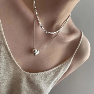 Double layered silver heart necklace with irregular faceted beads for a minimalist look