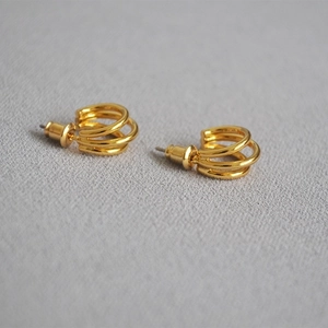 Orecchini a perno minimalisti placcati in oro a tre strati su una base di tessuto