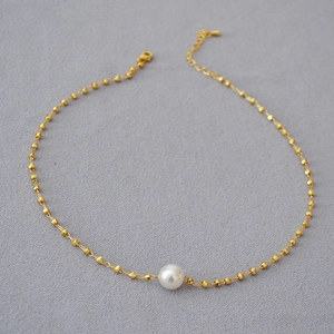 Elegant gold-plated bead necklace with white pearl and faceted metallic spheres