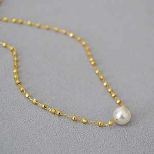 Elegant gold-plated brass necklace with faceted gold beads and a white pearl pendant