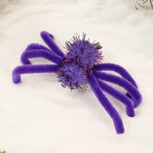 Macro detail of purple Halloween spider hair clip with shiny pink metallic bristles