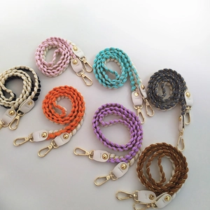 Detail of colorful woven shoulder straps with gold hardware and white leather connectors