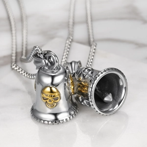 Macro shot of silver and gold skull bell pendant necklace with 1%er vintage carving