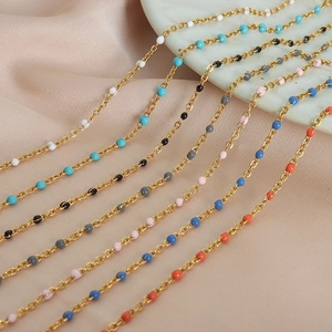 Elegant gold-plated titanium steel jewelry sets with colorful enamel beads displayed on marble