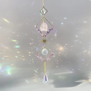 Crystal suncatcher with raw rose quartz and amethyst stones creating rainbow reflections
