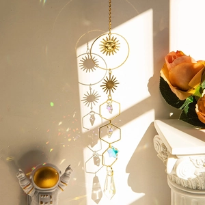 Crystal suncatcher with golden sun and hexagon frames casting rainbows on the wall