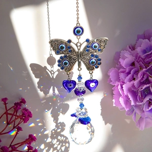 Silver butterfly evil eye pendant with crystal ball creating rainbow prism light effects