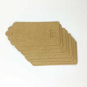 Close-up of brown kraft paper gift tags with scalloped edges and heart cut-outs