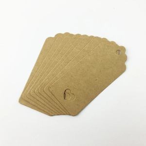 Macro shot of brown kraft paper gift tags with scalloped edges and heart-shaped cutout