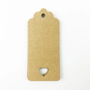 Close-up of brown kraft paper gift tags with heart-shaped cutout and pre-punched hole