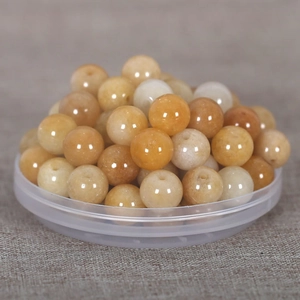 Macro shot of honey-colored natural stone round beads with holes for DIY jewelry making