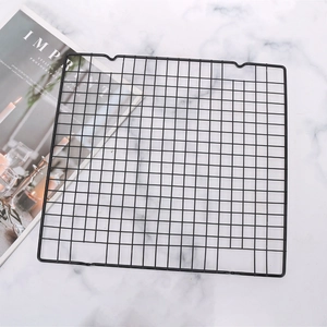 Non-stick black metal rectangular wire cooling rack for baking on marble background