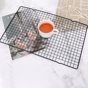 Non-stick black rectangle cooling rack for bread and cakes on a marble surface