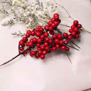 Artificial red berries stem for Christmas wreath and home decor on pink background