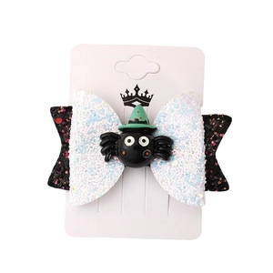 Halloween glitter bow hair clip with black spider and green wizard hat on card