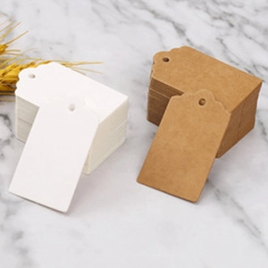 Detail of white and brown kraft paper heart gift tags on an elegant marble surface