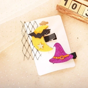 Detailed view of Halloween hair clips featuring a crescent moon with bat and wizard hat