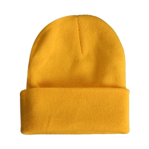 Detailed view of bright yellow knitted beanie with fine ribbing texture on white background
