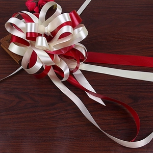 Top view of a large bicolor red and beige ribbon bow for gift and car decoration