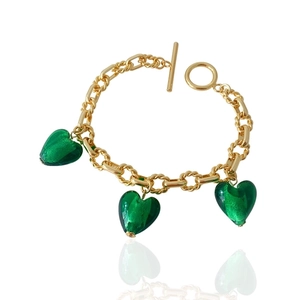 Detail of gold chain bracelet with three green heart glass pendants and toggle clasp