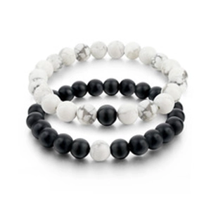 Detail of beaded bracelet set featuring black lava stone and white marble texture beads