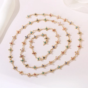 Detailed view of golden chain necklace with colorful evil eye cross charms in a spiral layout