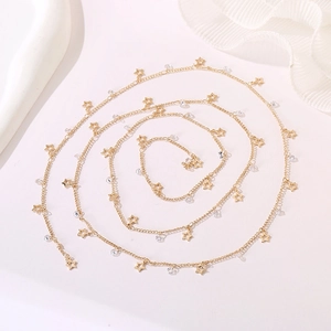 Detail of a gold body chain featuring hollow star pendants and clear crystal beads