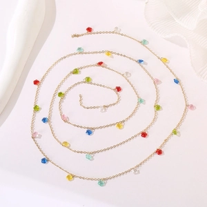 Macro shot of colorful star pendants on a golden long chain in a spiral layout