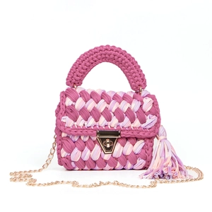 Close-up of pink and purple handmade crochet bag with gold lock and chain strap detail