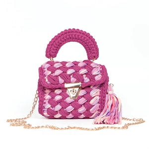 Detail of hand-woven colorful bag showing fuchsia texture, gold lock, and chain strap