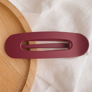 Close-up of minimalist burgundy matte duckbill hair clip with durable spring mechanism