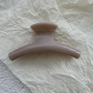 Detailed view of neutral taupe PC hair claw clip with glossy finish and curved minimalist design