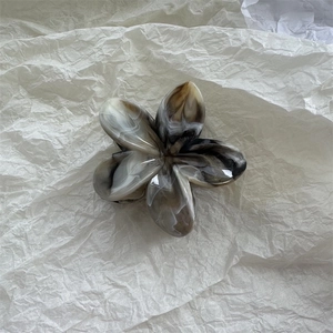 Macro view of flower hair claw clip with black and white marble texture patterns