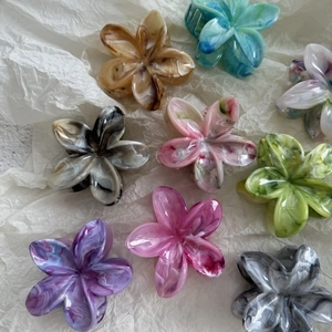 Floral marble pattern hair claws in multiple colors on a textured white background