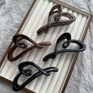Elegant heart-shaped hair claw clips in matte and glossy black or brown finishes