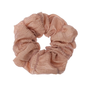 Detail of light brown champagne scrunchie with striped texture on white background