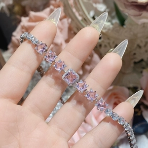Detailed close-up of pink square crystal and star-shaped zircon bracelet in 18K gold finish