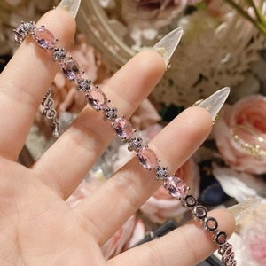 Macro detail of silver plated bracelet with oval pink gemstone and floral zircon accents