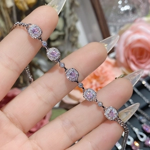 Macro view of square link chain bracelet with pink gemstone and zircon in 18K gold plating
