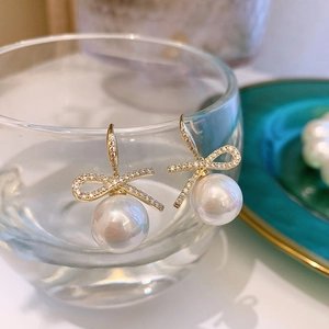 Elegant gold bow earrings with shimmering rhinestones and large white pearls for women