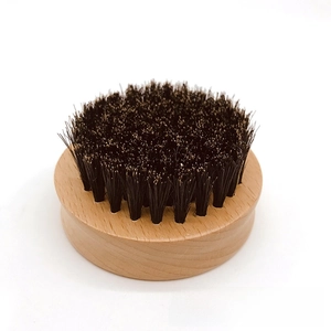 Macro view of men's curved wooden beard brush with dense black bristles and side grooves