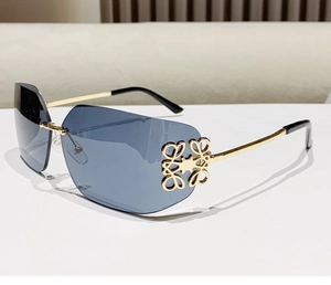 Close-up of golden metal hinges and blue gradient lenses on rimless sunglasses