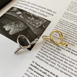 Detail of twisted knot 925 sterling silver rings in gold and silver finish on a magazine