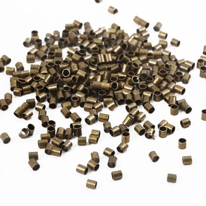 Makroaufnahme antiker Bronzemetallperlen und Quetschröhrchen für DIY-Schmuckherstellung