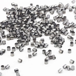 Makroaufnahme winziger zylindrischer Metall-Quetschperlen für DIY-Schmuckherstellung