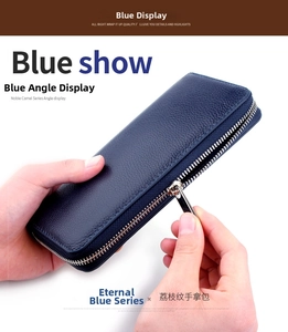 Detailed view of hands opening a navy blue pebbled leather long wallet with silver zipper