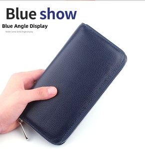 Close-up of hand holding a blue litchi grain leather long wallet with metal zipper